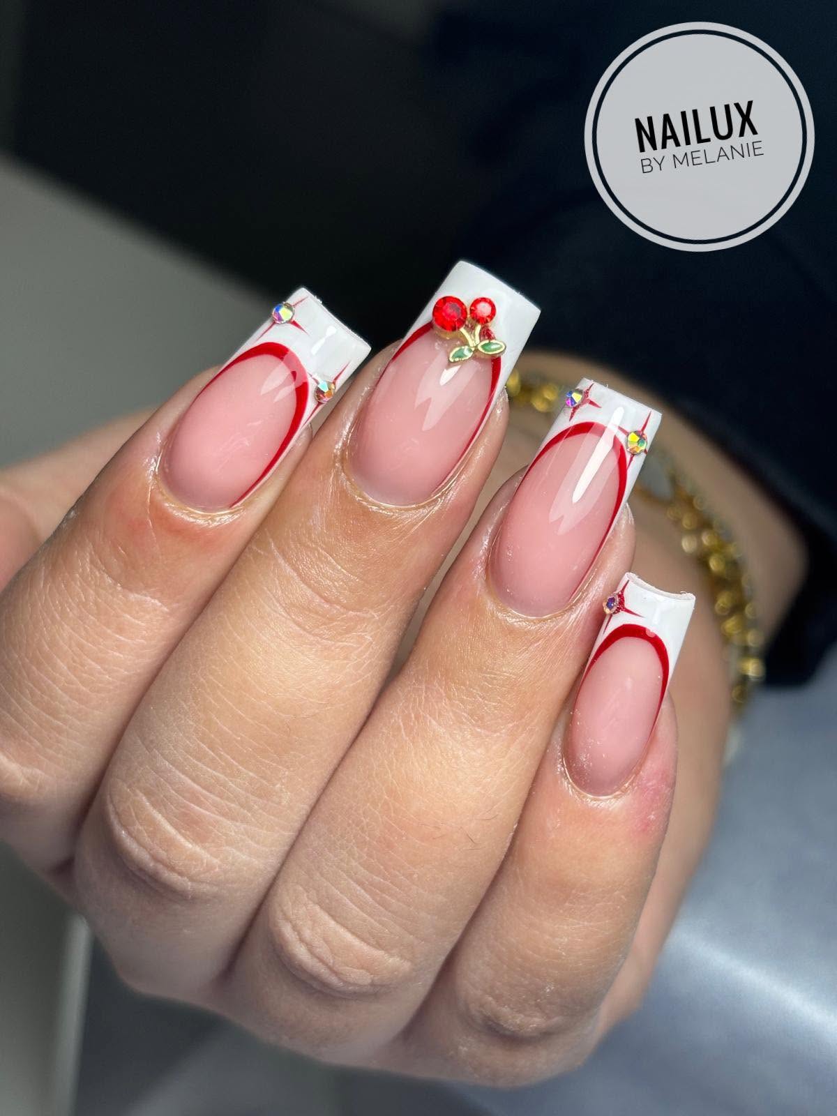 Red French tip nails with cherry gem nail art at NAILUX Beauty Studio Malta